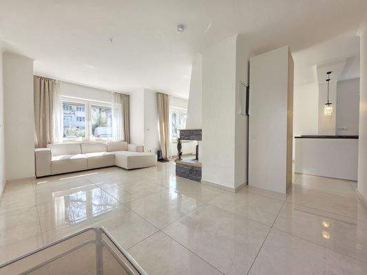 Offener Wohn-Essbereich mit einem Kamin mittig