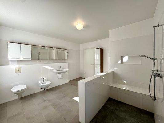 Badezimmer im Erdgeschoss, ausgestattet mit hochwertigen Fliesen von Villeroy & Boch, mit Bidet, großräumiger Dusche und Platz für Badewanne, Waschmaschine und Trockner und schallisolierter Tür