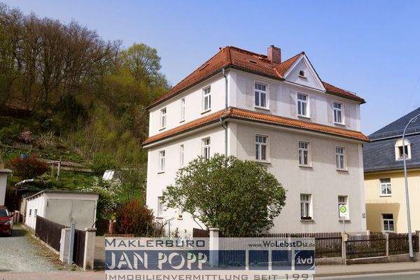 Ansicht mit Garage und Garten