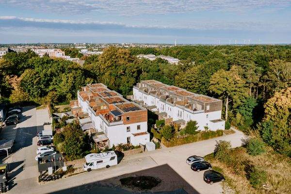 Straßenansicht mit begrünten Vorgärten und Stellplätzen direkt vor der Tür