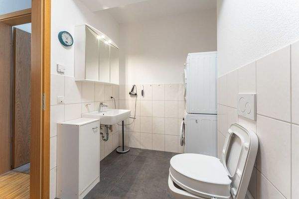 Badezimmer mit Dusche und Platz für Waschmachien und Trockner