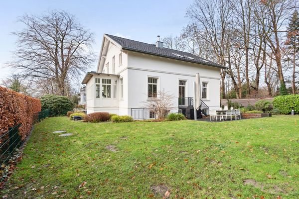 Elegante Seitenansicht der Stadtvilla mit stilvollem Wintergarten und einladender