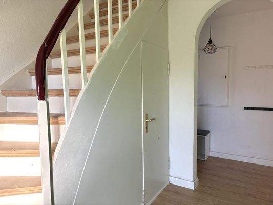 ...mit Aufgang ins Obergeschoss über die charmante Holztreppe