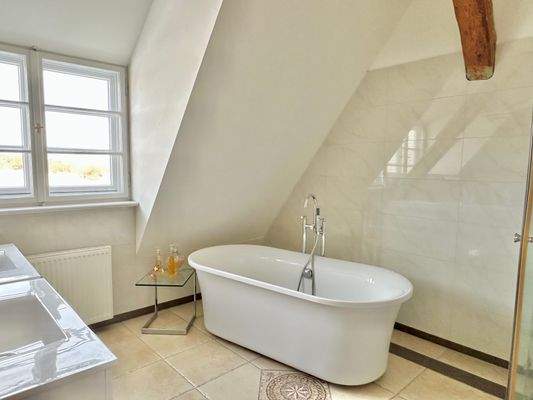 Ein  Badezimmer mit freistehender Badewanne und Dusche im Obergeschoss