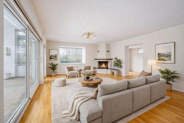 Lichtdurchfluteter Wohnbereich mit Kamin und Garte