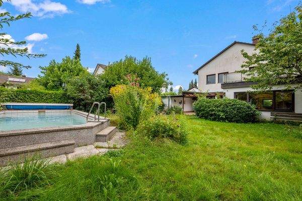 Ansicht vom Garten mit Pool auf das Haus von hinten 