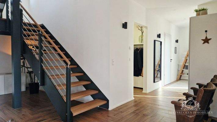 Eleganter Flur mit Design‑Treppe und klaren Linien