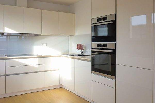 Hochwertige grifflose Küche mit Naturstein-Arbeitsplatte, Glas-Rückwand, Miele, Bosch Geräte 7,1 m²