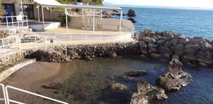 seichter Zugang Meer mit Steinmauer als Abgrenzung