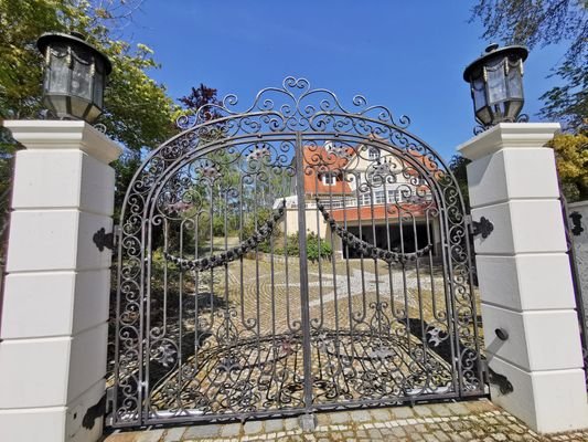 Elegantes Eingangstor mit Blick auf die Villa