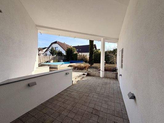 Überdachte Terrasse mit Gartenblick