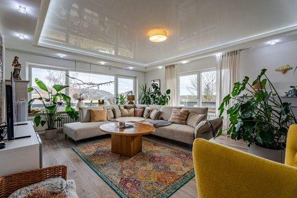 Lichtdurchfluteter Wohnbereich mit stilvollem Ethanol-Ofen und Balkonzugang