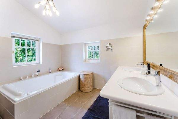 Das Tageslicht-Badezimmer mit Badewanne und Doppelwaschbecken