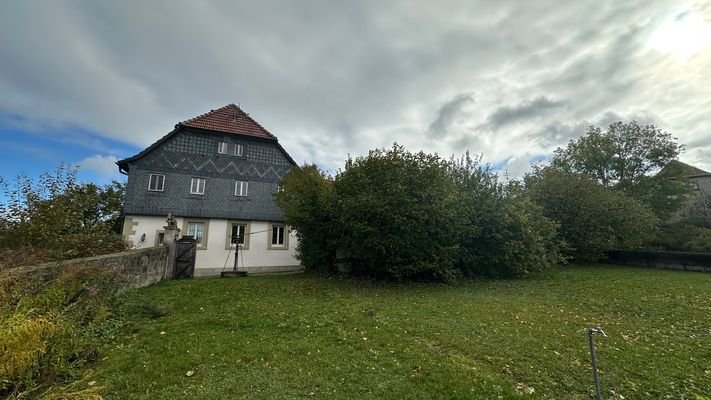 Blick aus dem Garten auf das Wohnhaus und Garage