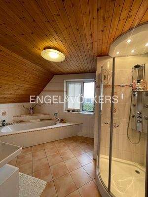 Großzügiges Badezimmer mit Eckbadewanne und einer Wellnessdusche