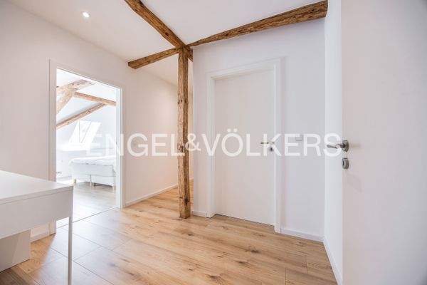 Heller Flur mit freigelegten Balken – harmonische Kombination aus historischem Charme und moderner Eleganz