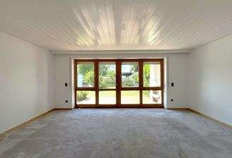 Wohnzimmer mit Fensterfront und Zugang zur Terrasse
