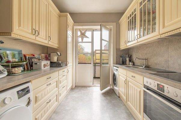 Klassische Küche einer Wohneinheit mit direktem Zugang zum Außenbereich