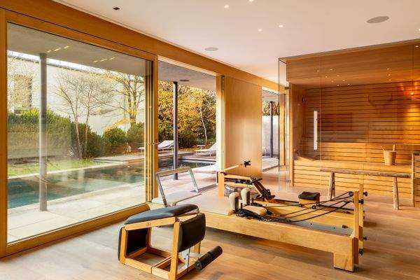 Zweites Wohnzimmer vor dem Pool als Fitnessbereich mit Sauna und Kamin