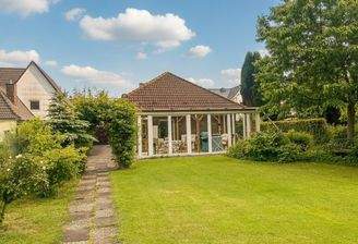 Moderner Wintergarten mit großflächiger Verglasung und direktem Gartenanbindung