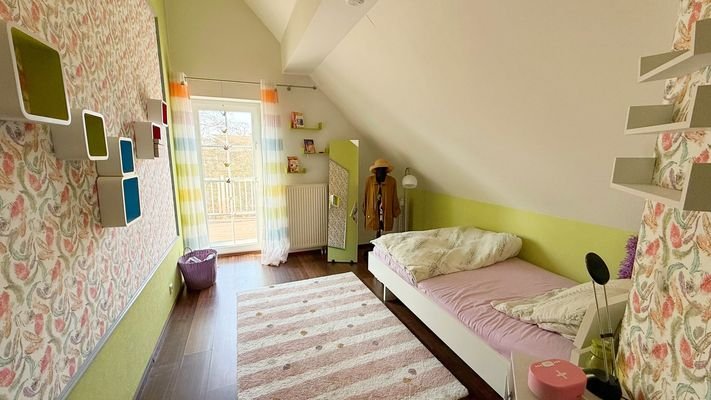 Schlafzimmer im Obergeschoss mit Zugang zum Balkon