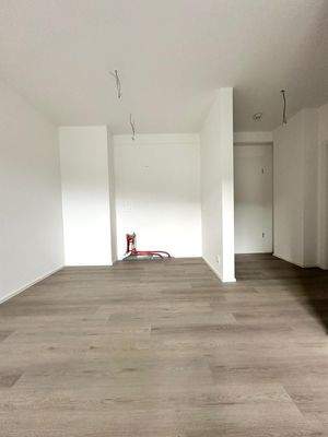 Wohn- und Esszimmerbereich mit offener Einbauküche