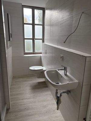 Badezimmer mit Dusche und Fenster