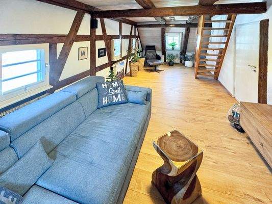 Schönes Wohnzimmer mit Fachwerkelementen und Zugang ins Dachgeschoss