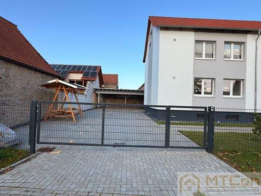 Einfahrt mit Stellplätzen + Carport