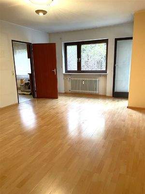 Wohnzimmer mit Zugang zur Küche und zum Balkon