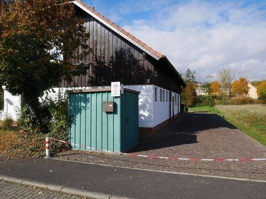 Straßenansicht mit Zufahrt zu den Parkplätzen