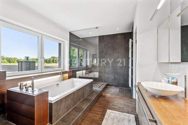 Badezimmer mit Dusche, Badewanne, WC und zwei Waschbecken