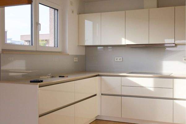 Hochwertige grifflose Küche mit Naturstein-Arbeitsplatte, Glas-Rückwand, Miele, Bosch Geräte 7,1 m²