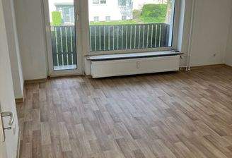 Wohnzimmer mit großem Panoramafenster und Glastür zum Balkon.jpg