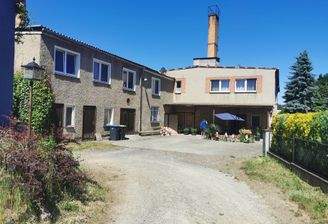 Einfahrt mit Blick zu den Hauptgebäuden