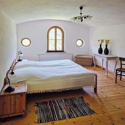 liebevoll eingerichtetes Schlafzimmer mit Rundbogenfenster