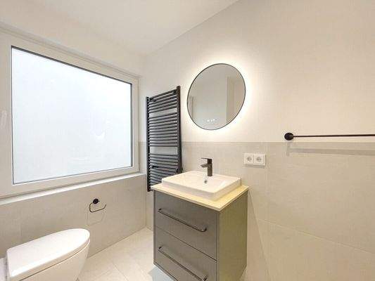 Großes Fenster im Bad und beleuchteter Spiegel