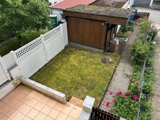 Blick vom Balkon auf Terrasse und Garten