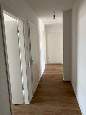 Flur mit weißen Wänden und braunen Vinyl-Designboden in Holzoptik