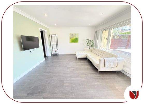 Hell und modern: der Wohnbereich mit gemütlichem Sofa und Fernsehr