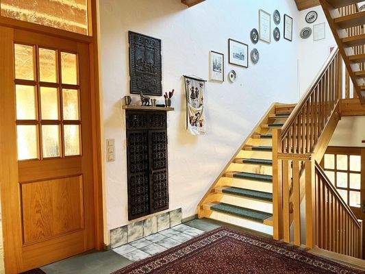 Einfamilienhaus - Treppenaufgang mit Schürstelle Kachelofen