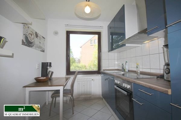 Moderne Einbauküche mit kleinem Esstisch