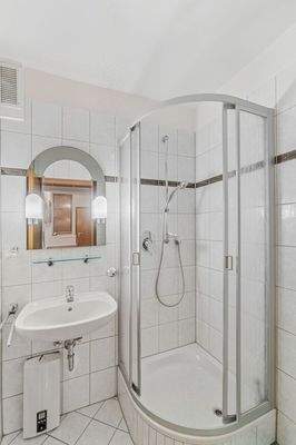 Innenliegendes Badezimmer mit Dusche und Waschtisch im Erdgeschoss