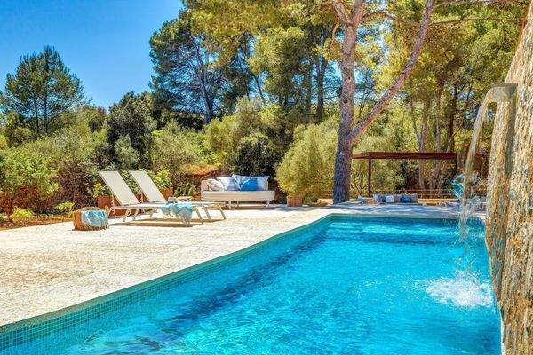 Privater Pool mit Wasserfall, umgeben von mediterraner Natur