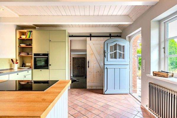 Moderne Küche mit Klöntür zur Frühstücksterrasse