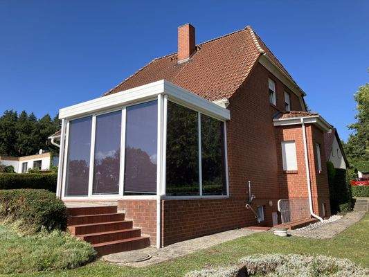 Wintergarten und Giebel mit Eingang zum Keller