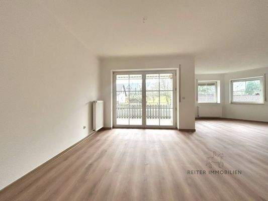 Großzügiger Wohnbereich mit Kamin und Balkonzugang