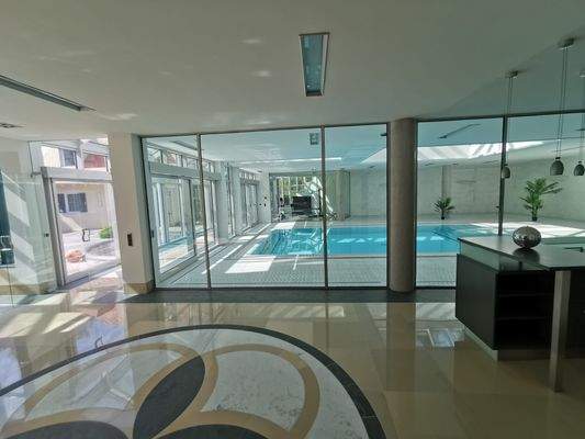Eleganter Spabereich mit Innenpool und großen Glasfronten