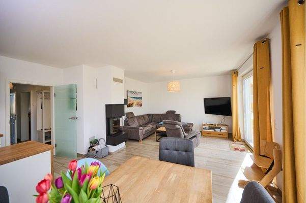 Blick in den offenen Wohnbereich mit Kaminofen und viel Tageslicht