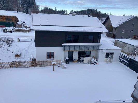 Außenansicht mit Sicht auf Photovoltaik und Gartenbereich